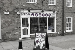 Derosa Music Academy storefront with a sign advertising music lessons.